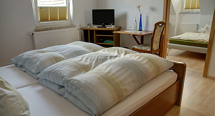 Blick ins Gästezimmer mit 3 Schlafmöglichkeiten im Gästehaus Kloep in der Eifel Schlafzimmer mit drei Betten im Gästehaus Kloep in Hillesheim