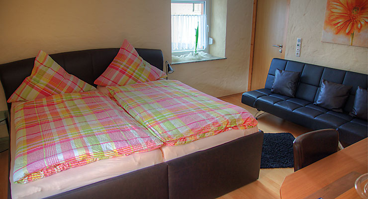 Gästezimmer mit Sofa und Dusche/WC im Gästehaus Kloep in der Eifel Gemütliches Gästezimmer mit Doppelbett und Couch im Gästehaus Kloep in Hillesheim